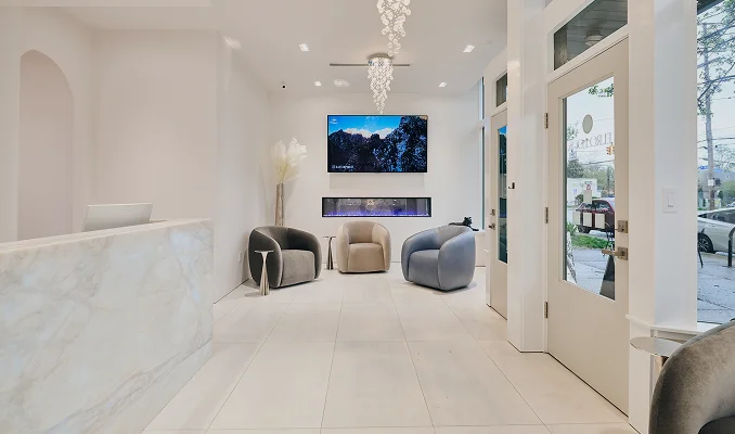 Modern white minimalist living room with mounted TV, contemporary furniture, and elegant lighting fixtures