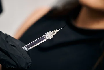 Healthcare worker in black gloves holding medical syringe for vaccination or injection procedure - injectables In Cleveland, OH